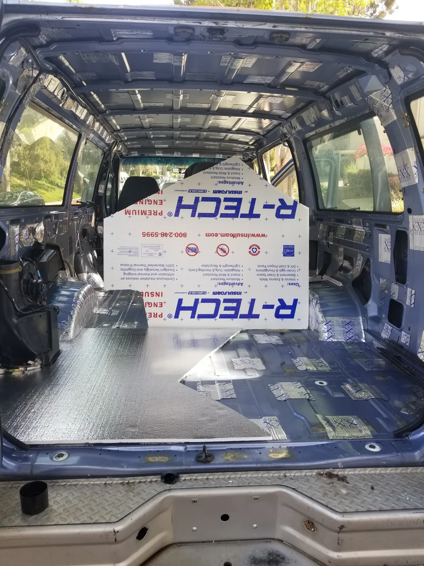 R-Tech foam board standing inside Walter beside partly fitted foil-faced floor insulation.