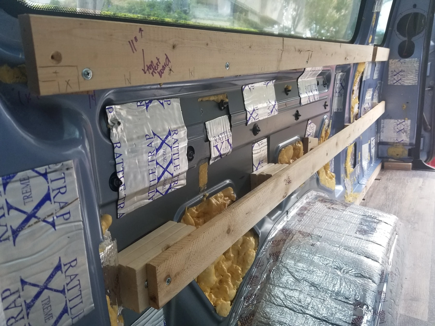 Horizontal timber strips on local spacer blocks along the curved van wall.